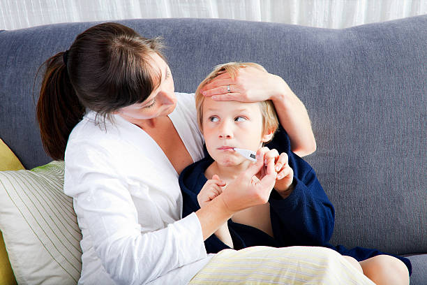 istock A mother taking the temperature of her sick son 182781519