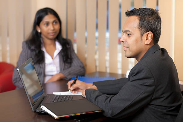 Two businessmen holding a meeting Businessman looking at laptop screen, working with colleague/client/customer in the office. sri lanka business stock pictures, royalty-free photos & images