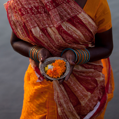 Indian woman  offering (Puja)  for the gods in Varanasi by Ganges River