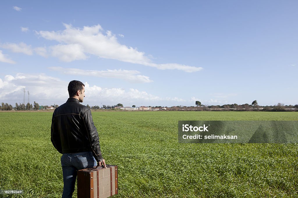若い男性の保持スーツケースの草地 - 1人のロイヤリティフリーストックフォト
