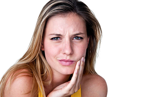 Woman with toothache Woman holding her jaw for a toothache concept jaw pain stock pictures, royalty-free photos & images