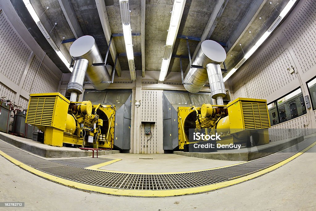Wide Agle View Two Backup Diesel Generators Two backup diesel generators in an industrial facility viewed with fish-eye lens. Generator Stock Photo