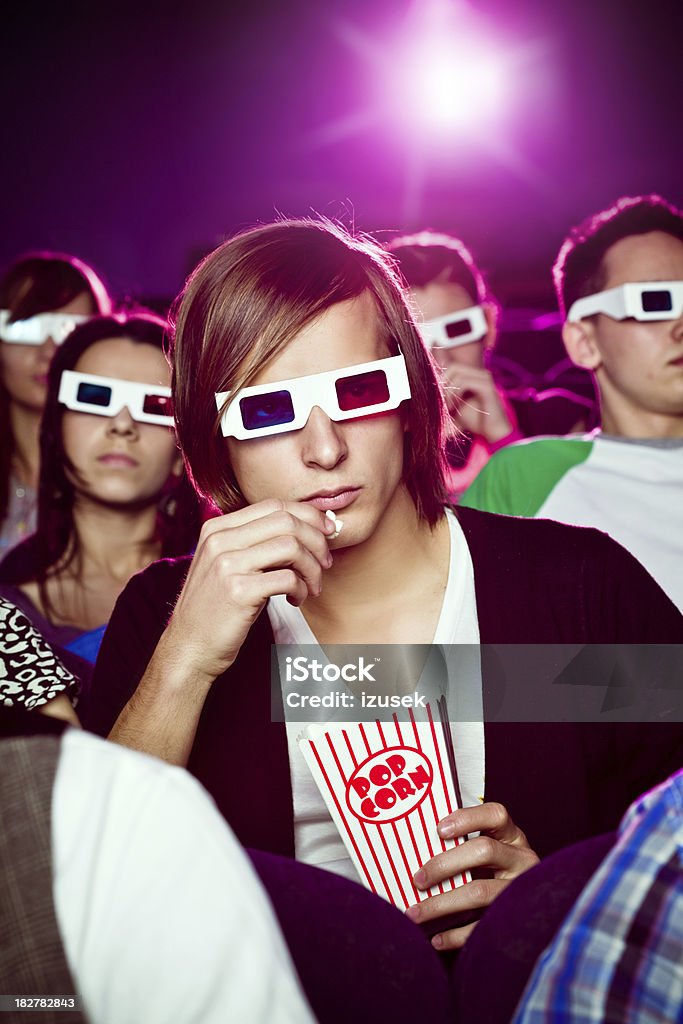 Young people in 3D move theater "Group of young adult people wearing 3D glasses, sitting in the cinema and watching 3D move." 3-D Glasses Stock Photo