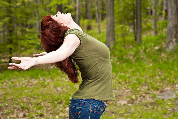 istock Young Woman in Forest with Hands Reached Back Looking Up 182783039