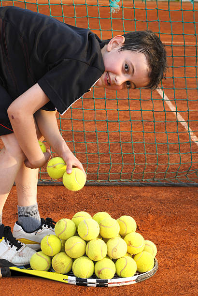 istock boy with tennis balls 182783893