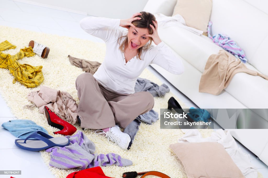 Mujer pateando sobre la situación en la habitación. - Foto de stock de Desordenado libre de derechos