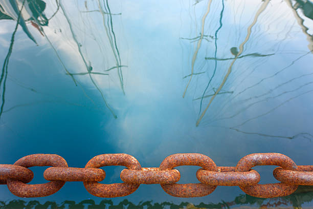 rusty anchor chain in marina and reflection of sailboats in the water, iStockalypse Cannes 2010 «Photographié à Cannes, Côte d’Azur, France. Shot in Cannes, Côte d’Azur, France»
