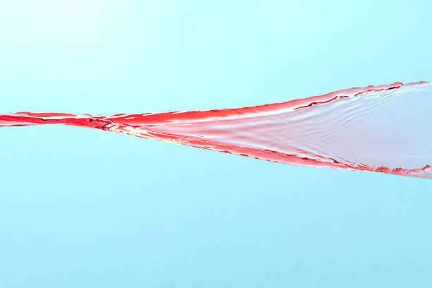 Red Water Splashing on Blue Background stock photo