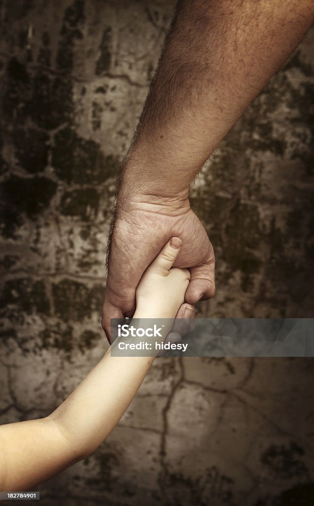 Learn and Trust "Dad holding little girls hand in front of grungy wall - symbolizes trust, education, help, support etc" Large Stock Photo