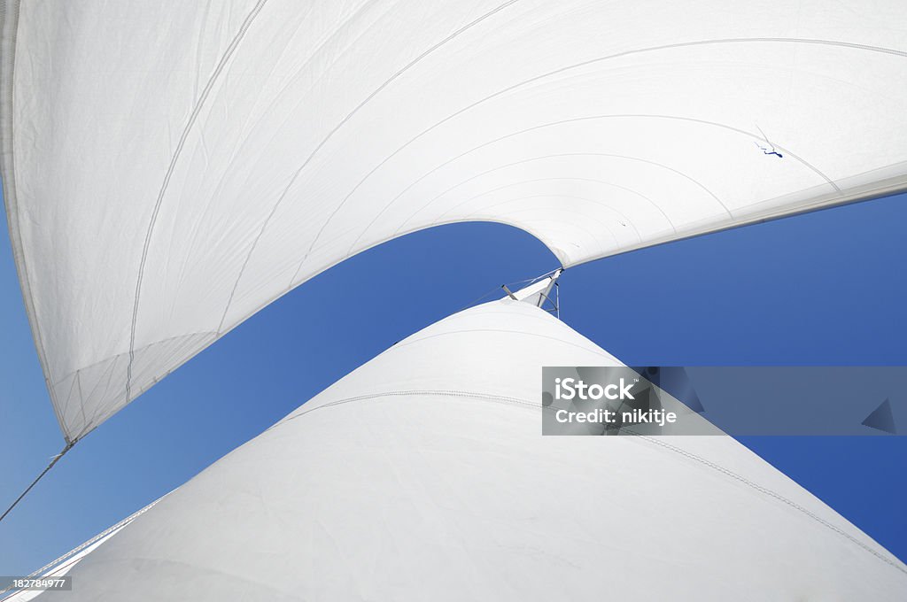 White sails Sails of the yacht (cutter rig) billowing in the wind.  Blue Mediterranean sky. Sail Stock Photo