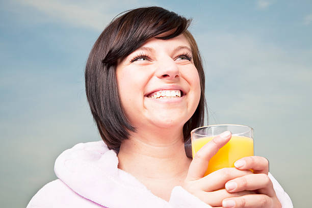 istock young woman drinking orange juice 182786061