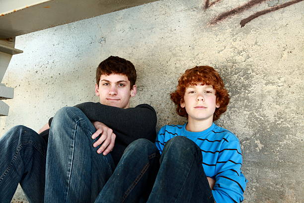 istock Brothers Sitting Together Against a Wall 182786098
