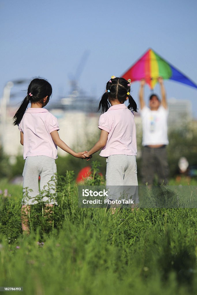 Holding Hands - XLarge Twin girl hand in hand and waiting father let kite taking off Child Stock Photo