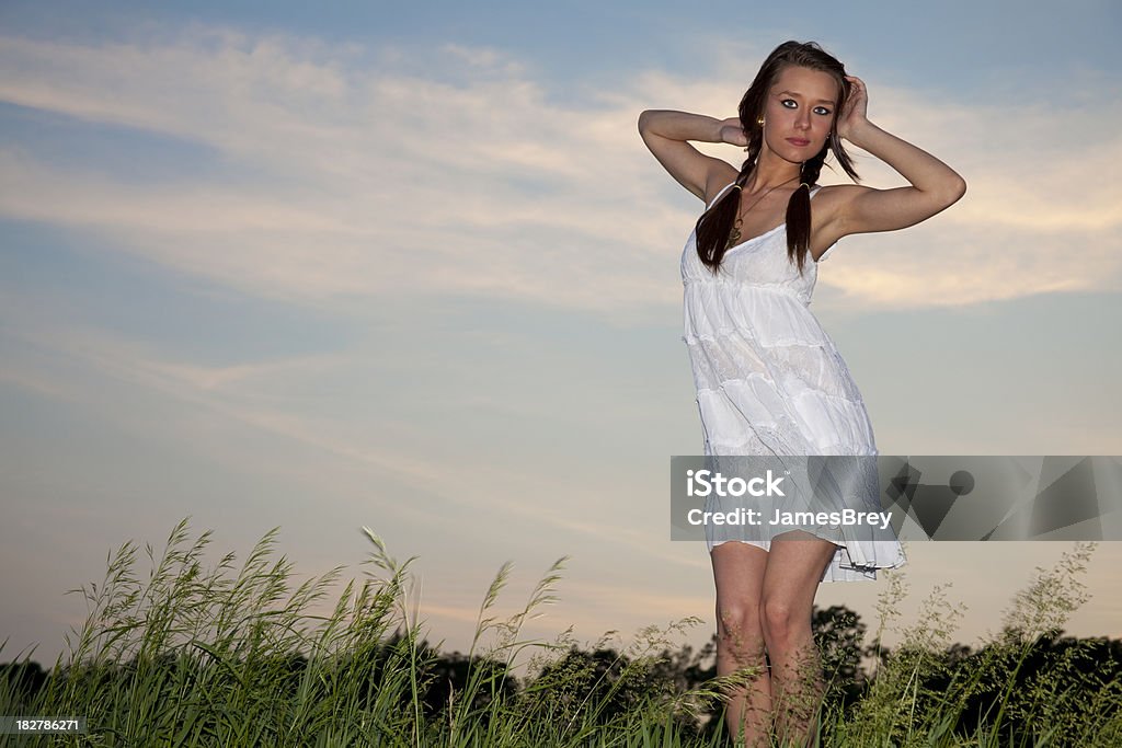 Schöne Frau, die weiß Kleid Tanzen in Abend Brise in der Dämmerung - Lizenzfrei Abenddämmerung Stock-Foto