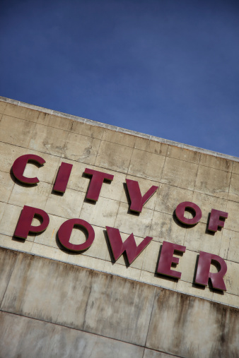 Outdoor vertical photo of abandoned electrical plant with large City of Power sign in deco style letters
