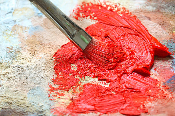 istock Paintbrush with red oil paint on a classical palette 182786689