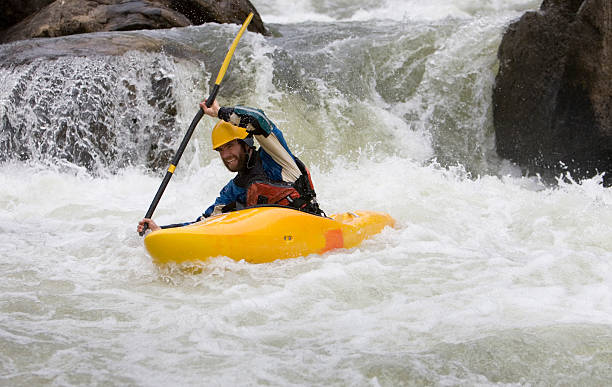 Man Paddling a White Water Kayak on an Idaho River.
