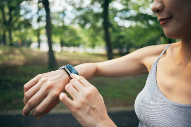 istock In the park, an Asian women engage in physical activities while utilizing smart devices to monitor their body data. 1827885916