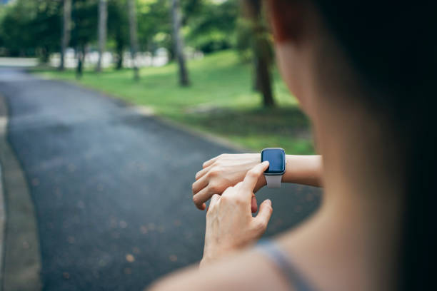 istock In the park, an Asian women engage in physical activities while utilizing smart devices to monitor their body data. 1827885919