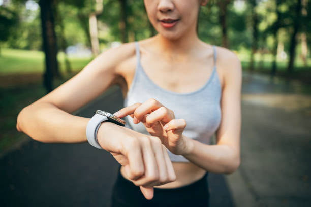istock In the park, an Asian women engage in physical activities while utilizing smart devices to monitor their body data. 1827885920