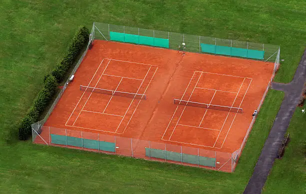 Two tennis courts with the approaching road.