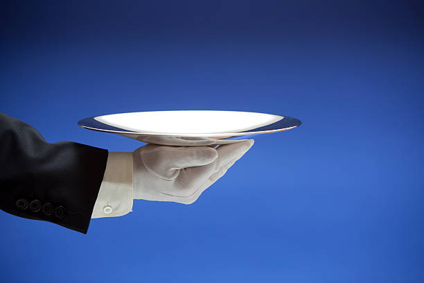 Butler Holding Empty Silver Tray on Blue XXL  silver platter stock pictures, royalty-free photos & images