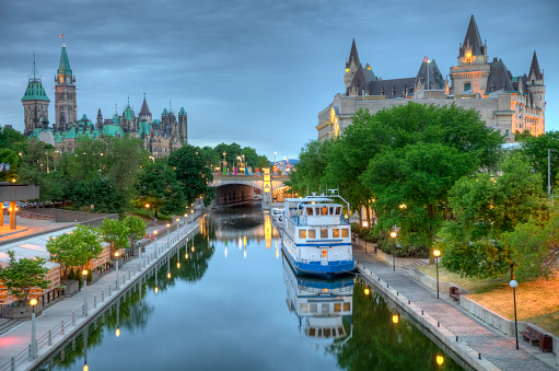 Parliament Hill along the banks of the Rideau Canal in Ottawa Ontario. Parliament Hill is home to Canada's federal government and is the centrepiece of Ottawa’s downtown landscape. Ottawa is known for is high-tech business sector, vast array of museums and high standard of living.