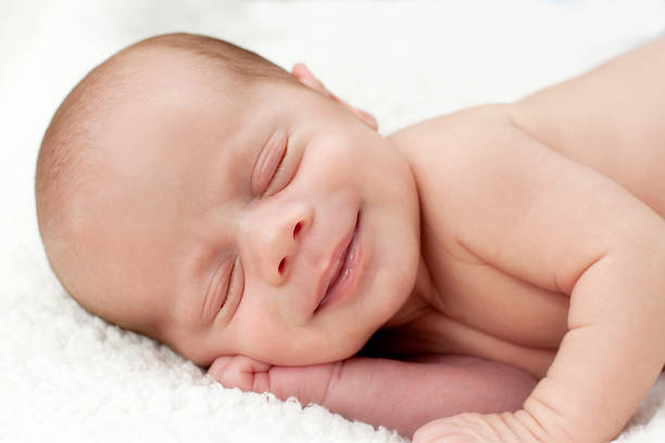 istock Sleeping newborn with big smile 182789853