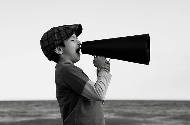 istock Little boy shouting through an old fashioned megaphone in outdoor 182789957