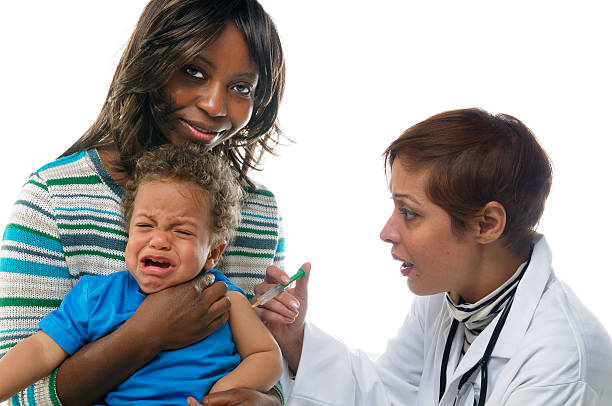 bébé pleurer tout en ayant une injection - male nurse nurse doctor group of people photos et images de collection