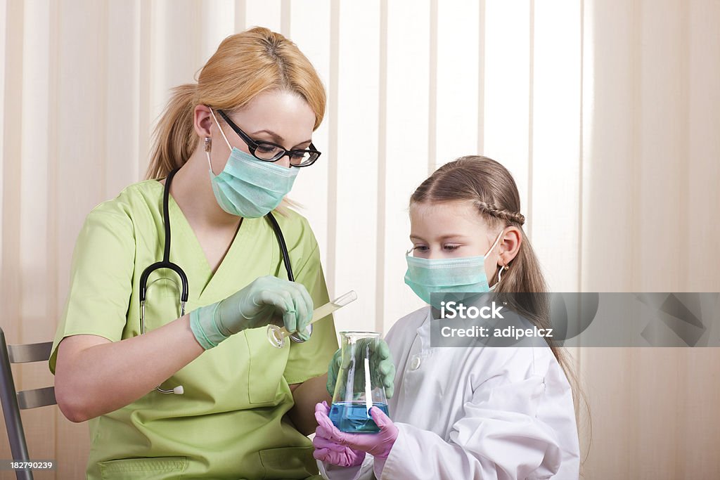 Petite fille et Jeune médecin en laboratoire simulant expériences - Photo de Adulte libre de droits