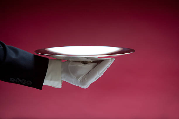 butler che tiene vuoto vassoio d'argento su rosso xxl - serving tray silver plate foto e immagini stock