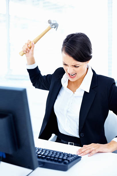 istock Angry business lady hitting a computer keyboard with hammer 182791457