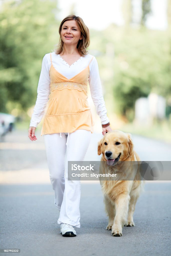 Niña con perro caminando al aire libre - Foto de stock de Adulto libre de derechos