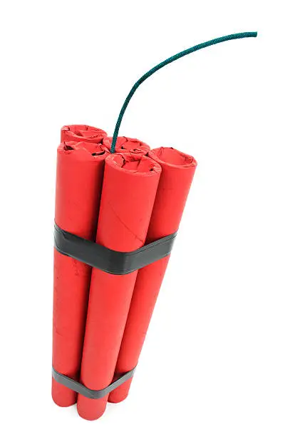 Close-up of 5 sticks of red dynamite taped together with fuse against a white background