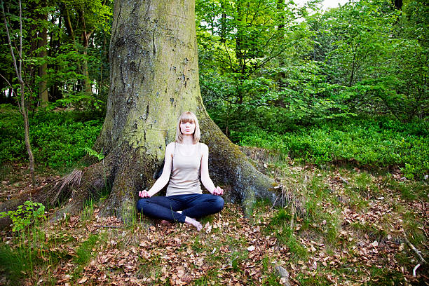 istock young woman meditating in forest 182792442