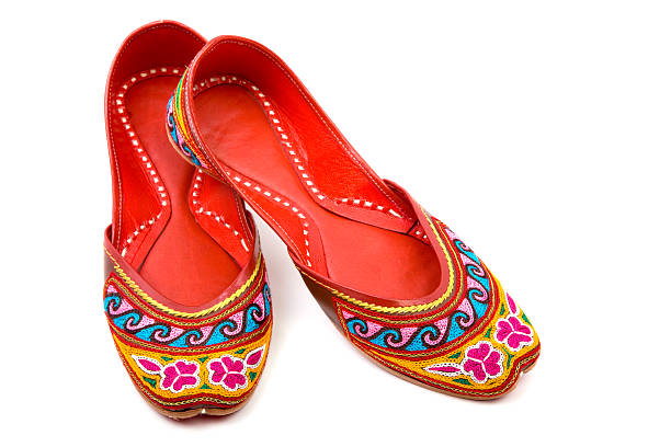 Handmade Multicolored Indian Shoes On White Background Handmade Multicolored Indian Shoes On White Background.the colors are red,blue,pink,yellow,green.The perfect stitchings (sewing) inside are seen.Horizontal composition.Shot with a full frame DSLR camera handmade indian shoes on white stock pictures, royalty-free photos & images