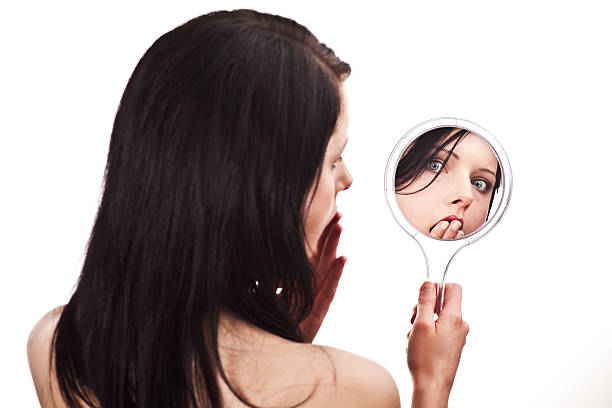 istock young anxious black hair woman looking through a mirror 182793140