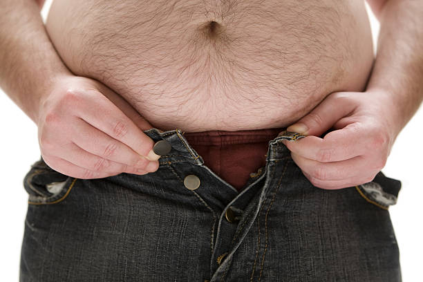 Too Fat for his Pants Fat man trying to get his pants on. White background. hairy fat man pictures stock pictures, royalty-free photos & images