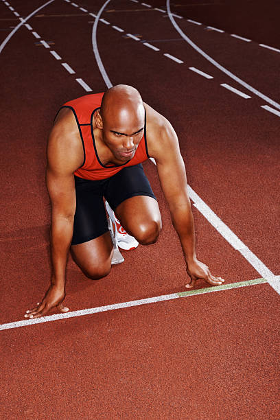 istock Male athlete in start position on a running track 182794499