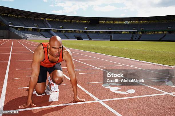 Atleta In Posizione Start Sulla Pista Da Corsa - Fotografie stock e altre immagini di Blocco di partenza per l'atletica - Blocco di partenza per l'atletica, Uomini, Punto di vista frontale