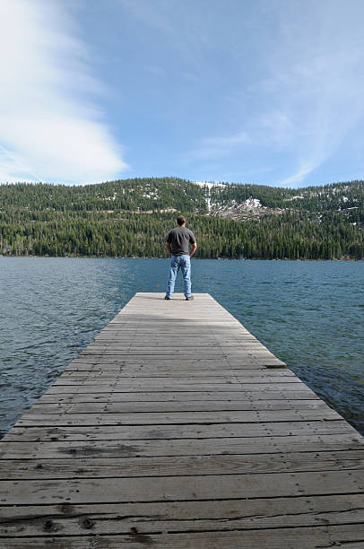 istock One Man on the Lake Pier 182794681