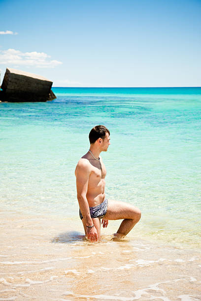 istock Young Man Kneeling On Waterline Looking At Horizon 182795047