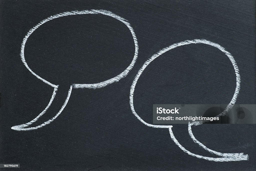 Chalk speech bubbles Two speech bubbles drawn in chalk on a blackboard. Space for copy. Black Color Stock Photo