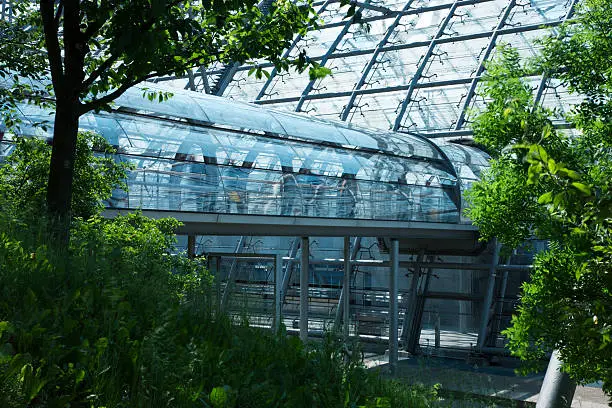 Photo of Modern Glass Building with Footbridge in Natural Environment