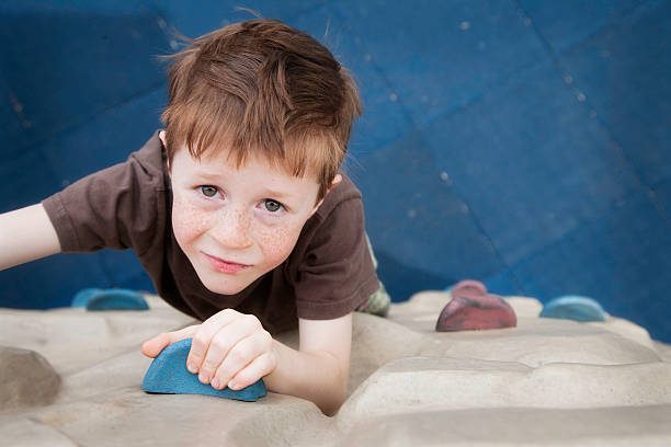 istock Young boy climbing up a wall at the playground 182796014