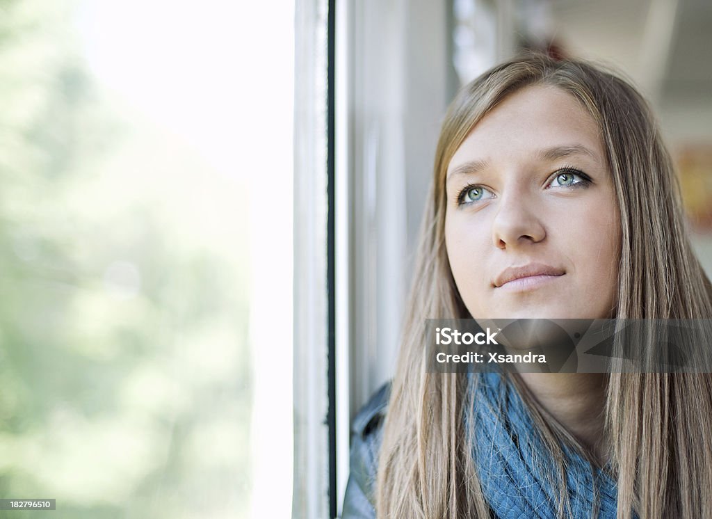 Young woman portrait Teenage girl looking through window Blond Hair Stock Photo