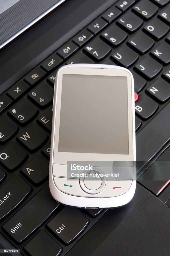 white mobile phone on the laptop mobilephone and laptop Black Color Stock Photo