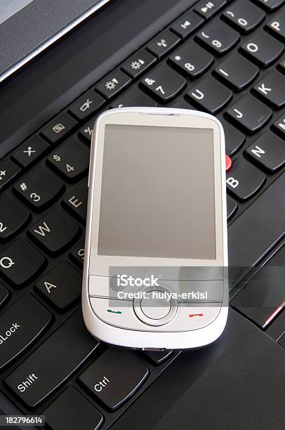 White Mobile Phone On The Laptop Stock Photo - Download Image Now - Black Color, Communication, Computer