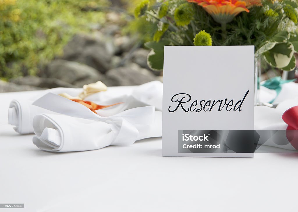 Reserved Table at Wedding Reception A reserved table at an outdoor wedding reception. Reserved Sign Stock Photo